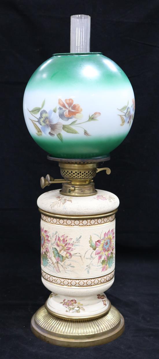 A ceramic based and floral glass shaded oil lamp